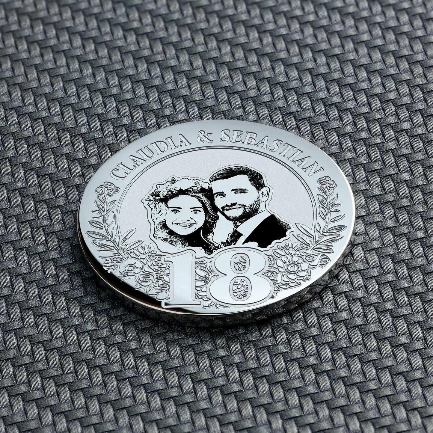 Nahaufnahme einer silbernen Münze zum 18. Hochzeitstag mit der Gravur eines Paares und der Zahl 18.