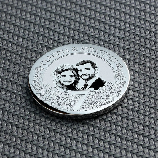 geschenk 7. hochzeitstag - Nahaufnahme der silbernen Münze zum 7. Jahrestag, mit detaillierter Gravur des Paares und des Datums.