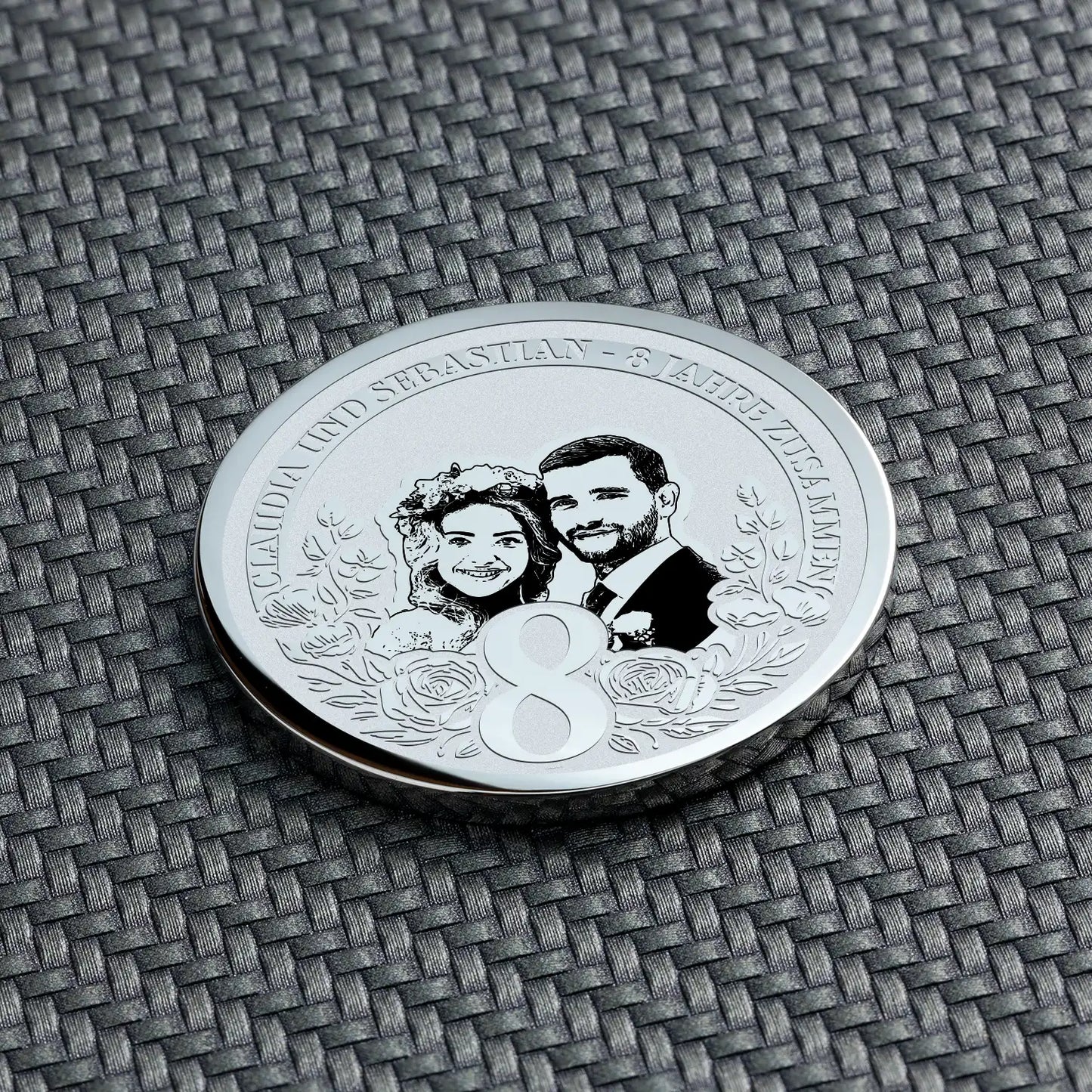 Detailaufnahme einer personalisierten Münze zum 8. Hochzeitstag aus Silber, mit Porträt eines Paares und der Zahl 8.