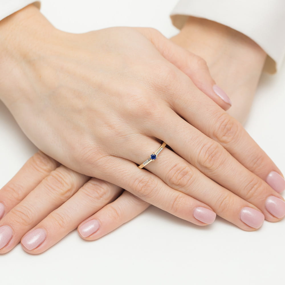 Wunderschöner Verlobungsring aus 585er Gelbgold mit einem runden blauen Saphir und kleinen seitlichen Diamanten.