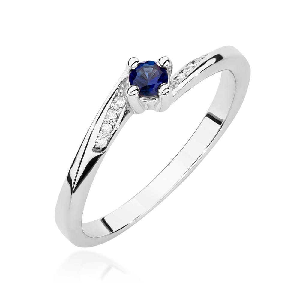 Weißgoldener Verlobungsring mit einem blauen Saphir und acht Diamanten. Die Diamanten sind in das Band eingearbeitet, was dem Ring einen eleganten Look verleiht.