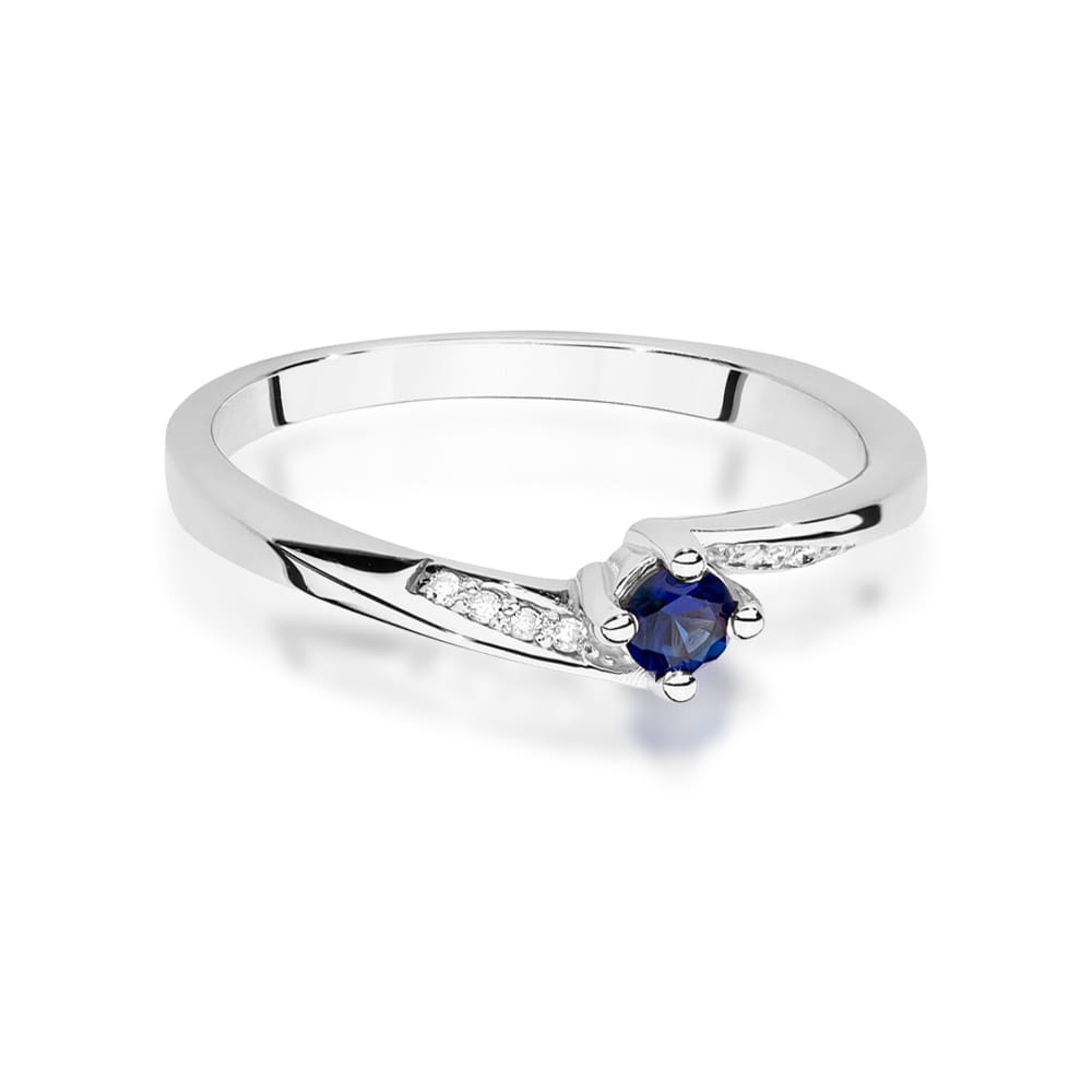 Verlobungsring aus Weißgold mit einem runden blauen Saphir in der Mitte und kleinen Diamanten auf dem Band. Das Design ist schlicht und stilvoll.