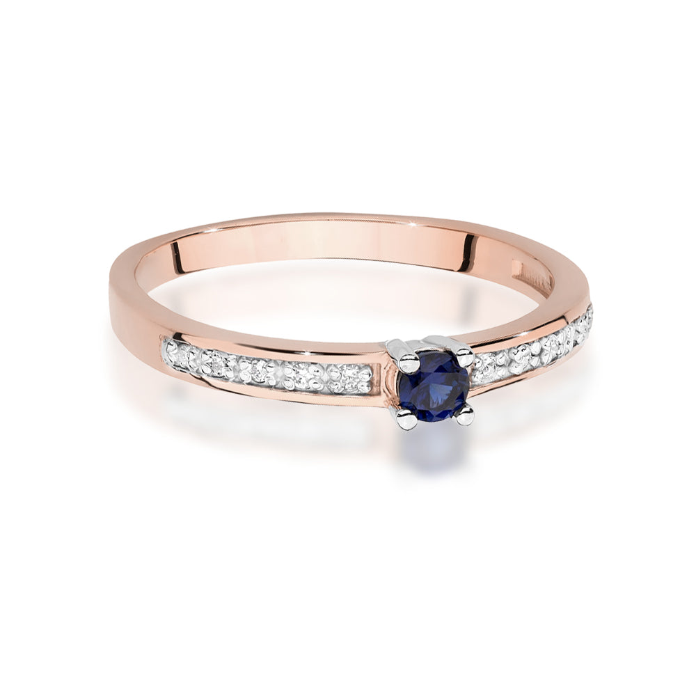 Ein detailliertes Bild eines Verlobungsrings aus Roségold mit einem zentralen blauen Saphir und kleineren Diamanten entlang der Ringschiene. Die hochwertige Verarbeitung und das glänzende Finish sind deutlich sichtbar.