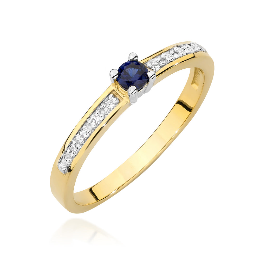 Ein goldener Verlobungsring mit einem zentralen runden blauen Saphir und mehreren kleinen, in der Ringschiene eingefassten Diamanten. Der Saphir strahlt in tiefem Blau, umgeben von funkelnden Akzenten.