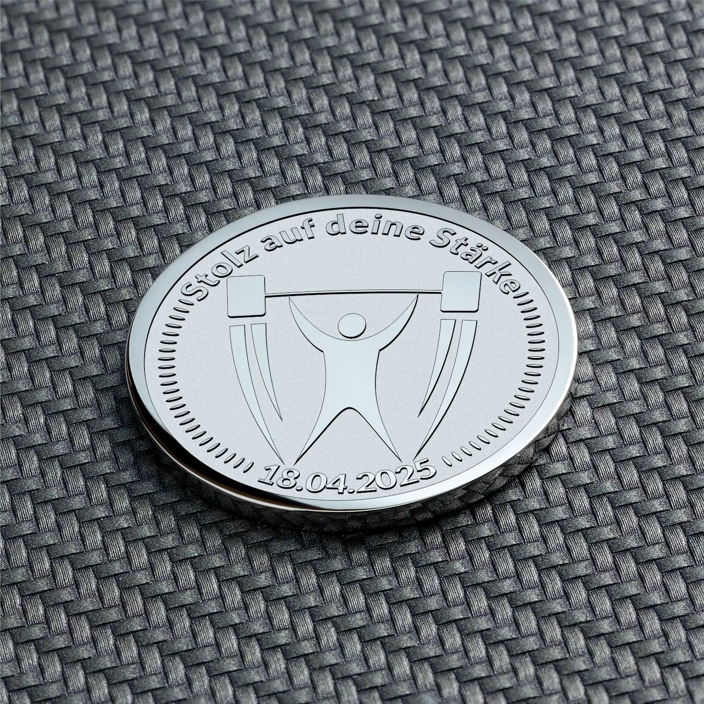 Silberne Münze mit Gewichtheber-Symbol und Datum graviert