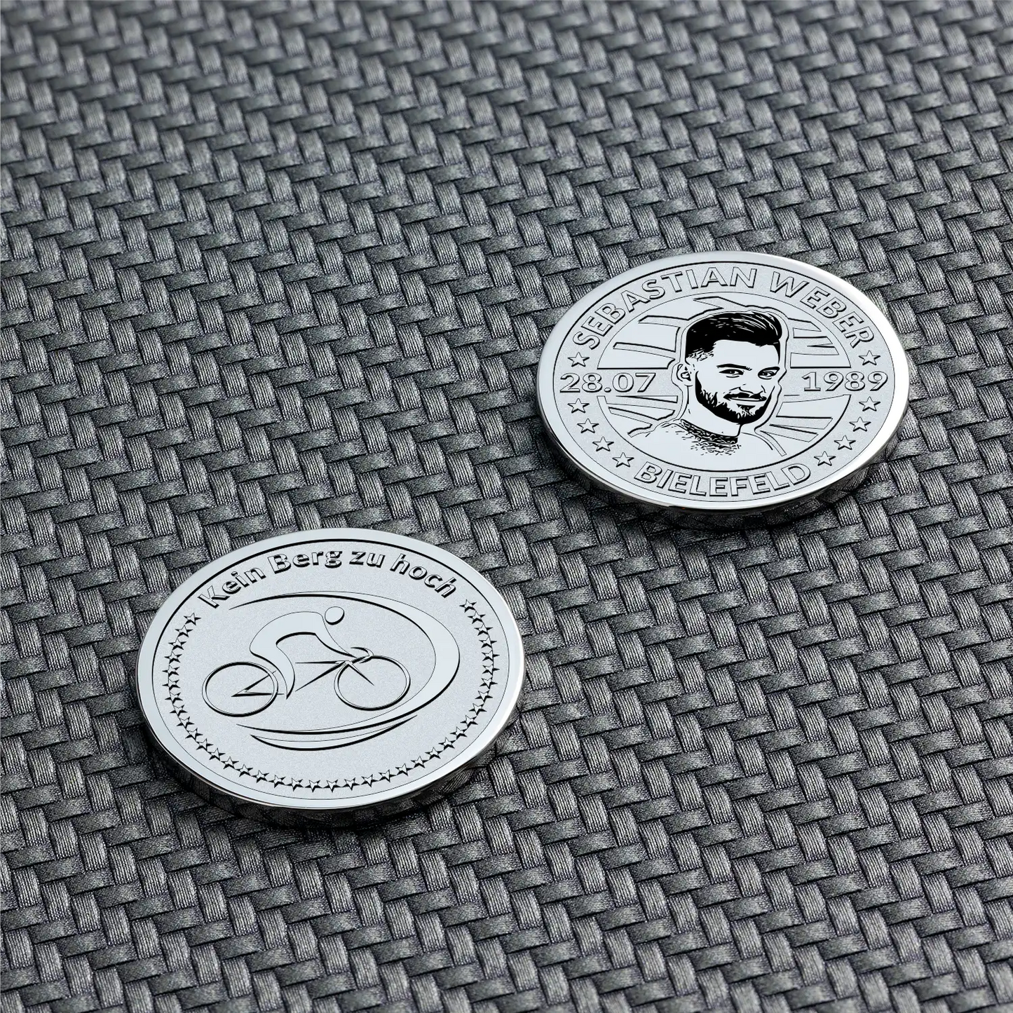 Zwei silberne Münzen mit Fahrrad-Symbol und Porträtgravur