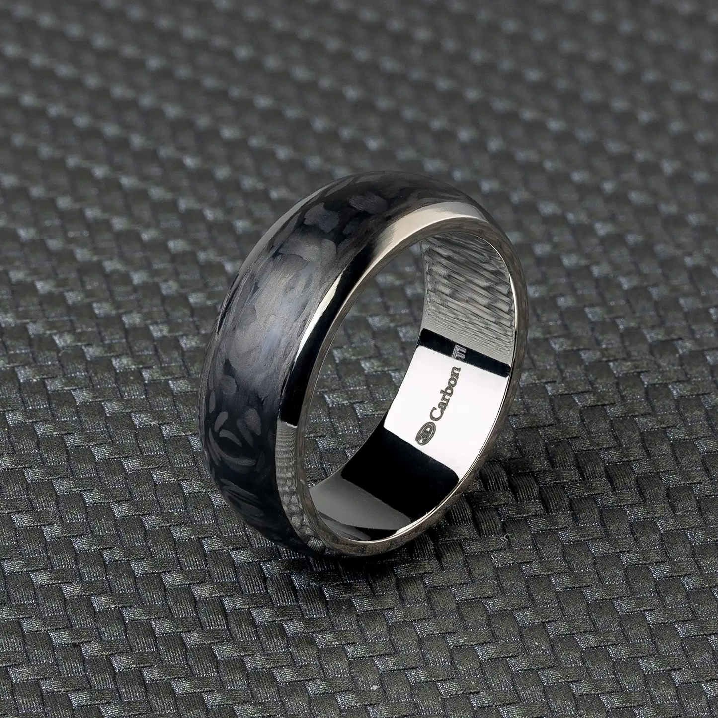 Schwarzer Titan- und Carbonfaser-Ring auf texturiertem Hintergrund