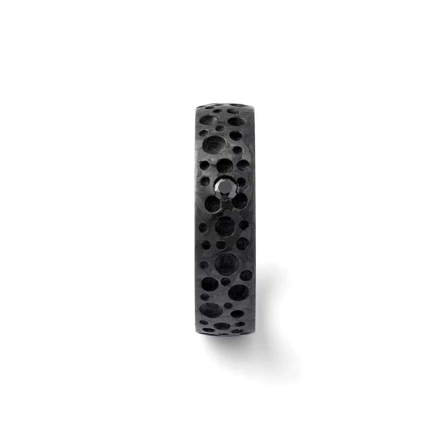 Seitenansicht eines Carbonrings mit Mondkratertextur und einem schwarzen Diamanten oder Zirkonia auf weißem Hintergrund.