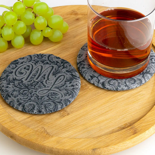 Schieferuntersetzer mit individuellem Monogrammgravur, stilvoll arrangiert mit einem Getränk auf einem Holztablett – ideal für besondere Anlässe.
