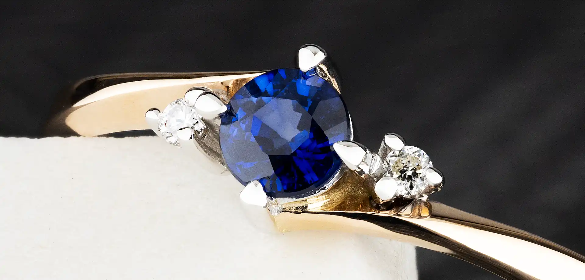 Verlobungsring aus 585er Gold mit einem tiefblauen Saphir und funkelnden Diamanten. Elegantes Design mit moderner Fassung, kombiniert aus Gelbgold und Weißgold. Perfekt für einen stilvollen Heiratsantrag.