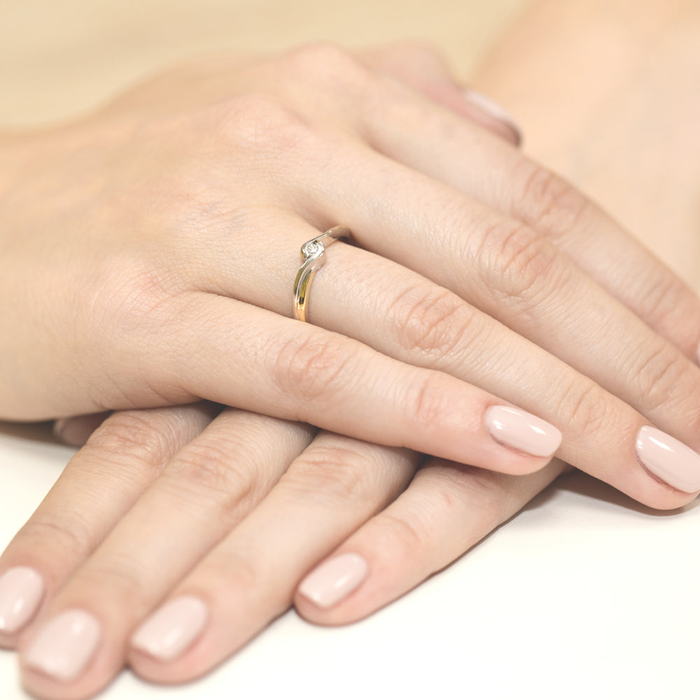Eleganter Verlobungsring aus 585er Gold mit einem Diamanten, getragen an der Hand.