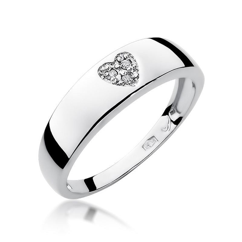 Das Bild zeigt einen silbernen Ring mit einem herzförmigen Diamanten in Nahaufnahme. Der Ring hat eine glatte, glänzende Oberfläche und das Herz ist mit kleinen Diamanten besetzt.