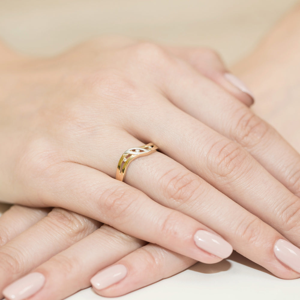Eleganter Verlobungsring aus 14k Gold mit einem geschwungenen Design und einem funkelnden Diamanten, getragen an einer Hand.