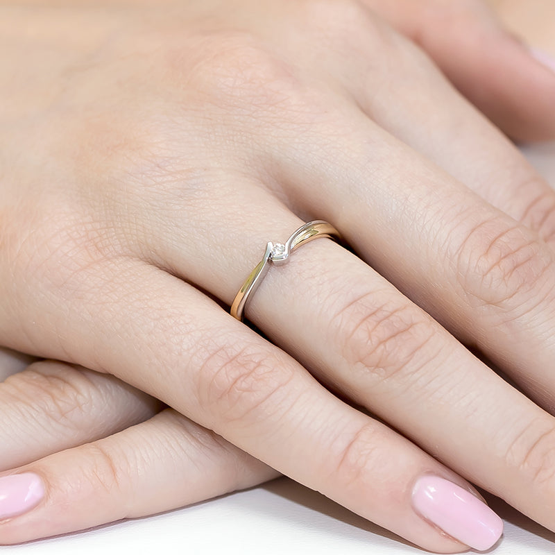 Ein eleganter Verlobungsring aus 14K Gold mit einem 0,04ct Diamanten, der an einer Hand getragen wird. Der Ring hat ein schlichtes und modernes Design, das Eleganz und Schlichtheit verbindet.