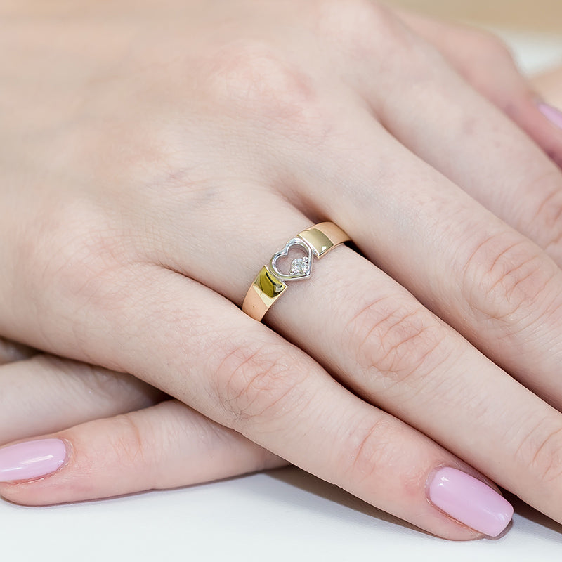 Ein eleganter Verlobungsring aus 585er Gold mit einem funkelnden Diamanten in Herzform. Der Ring ist an einer Hand getragen und zeigt die exquisite Handwerkskunst und das glänzende Finish.