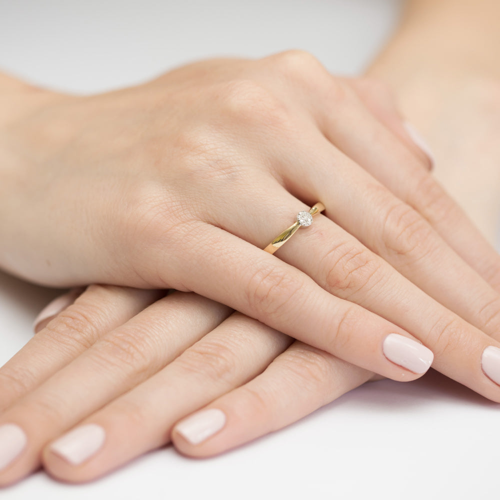 Eleganter Verlobungsring in 14K Gold mit einem Diamanten auf einer Hand präsentiert.