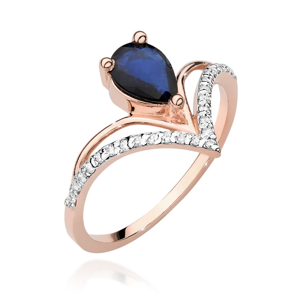Diese Aufnahme zeigt einen Verlobungsring aus Roségold mit einem birnenförmigen blauen Saphir und 24 Diamanten. Der Ring hat eine elegante V-Form und die Diamanten sind entlang der Schiene gesetzt.
