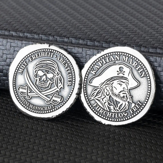 Beide Seiten der personalisierten Piratenmünze aus 925er Silber mit Kapitänsporträt und Totenkopf über gekreuzten Säbeln