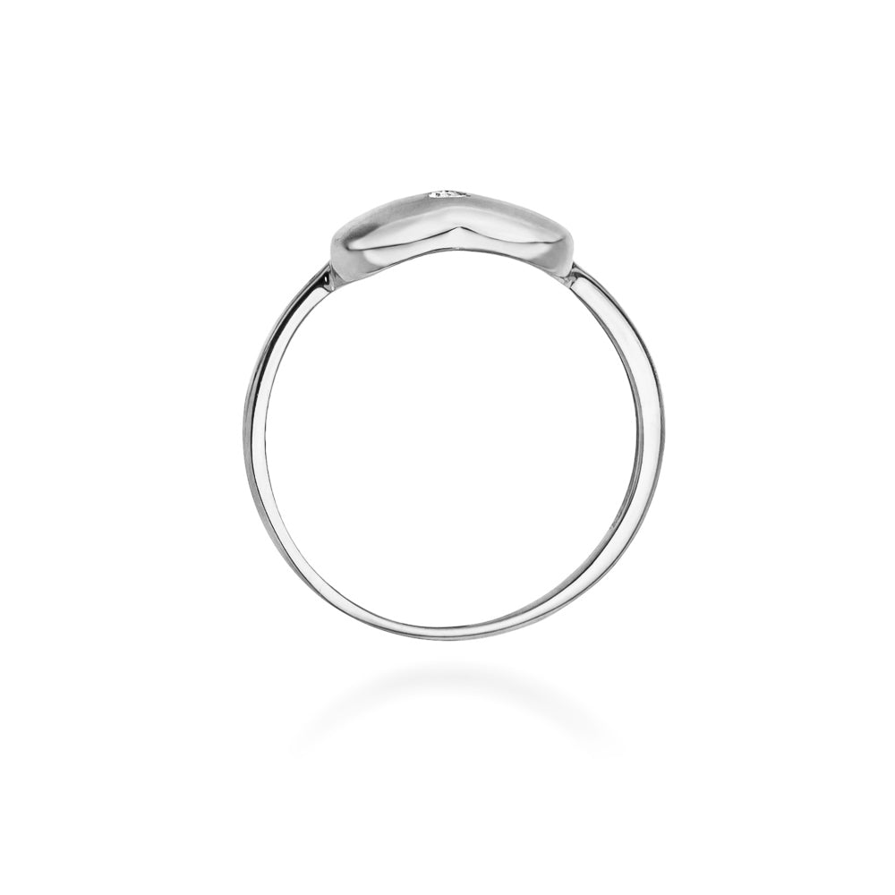 Ein Weißgoldring mit einem herzförmigen Design und einem kleinen, zentralen Diamanten. Der Ring ist an einer Hand getragen und zeigt die elegante Schlichtheit des Designs.