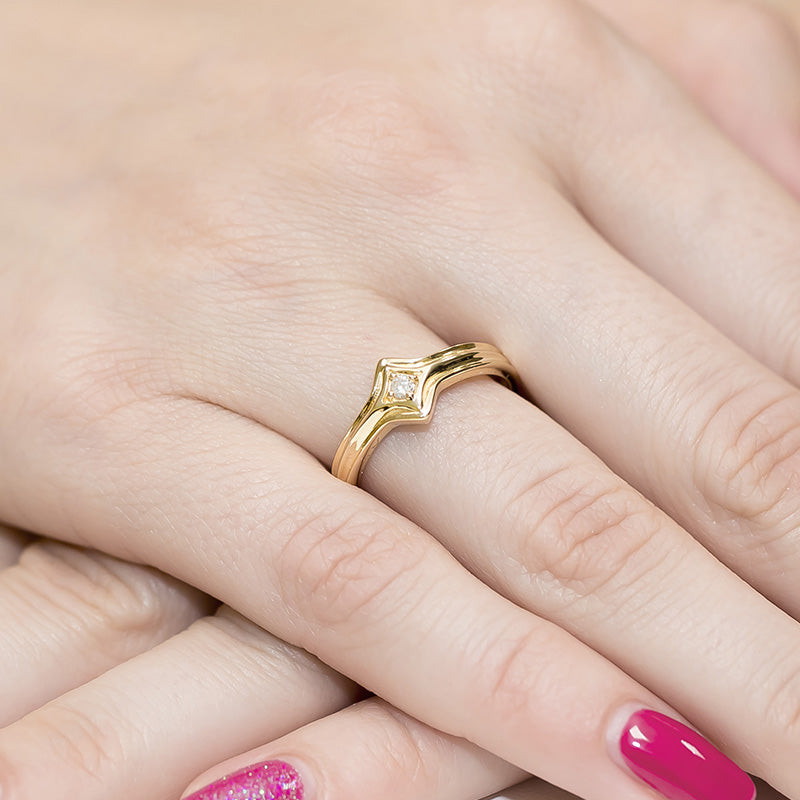 Dieser wunderschöne Verlobungsring aus Gelbgold 585 hat eine glänzende, glatte Oberfläche. Er besitzt eine elegante, geschwungene Form mit einem zentralen, funkelnden Diamanten.