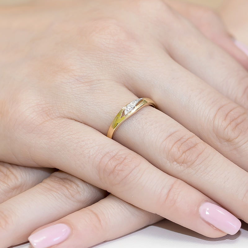 Nahaufnahme eines Goldrings 585 mit einem Diamanten von 0,03ct, der an einem Finger getragen wird. Der Ring hat ein elegantes und schlichtes Design mit einer glänzenden Oberfläche.