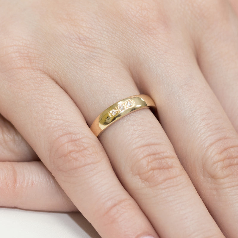 Dieser Verlobungsring aus Gelbgold 585 hat eine glänzende Oberfläche und ist mit drei kleinen Diamanten besetzt. Der Ring wird an einer Hand getragen und zeigt seine elegante und hochwertige Verarbeitung.