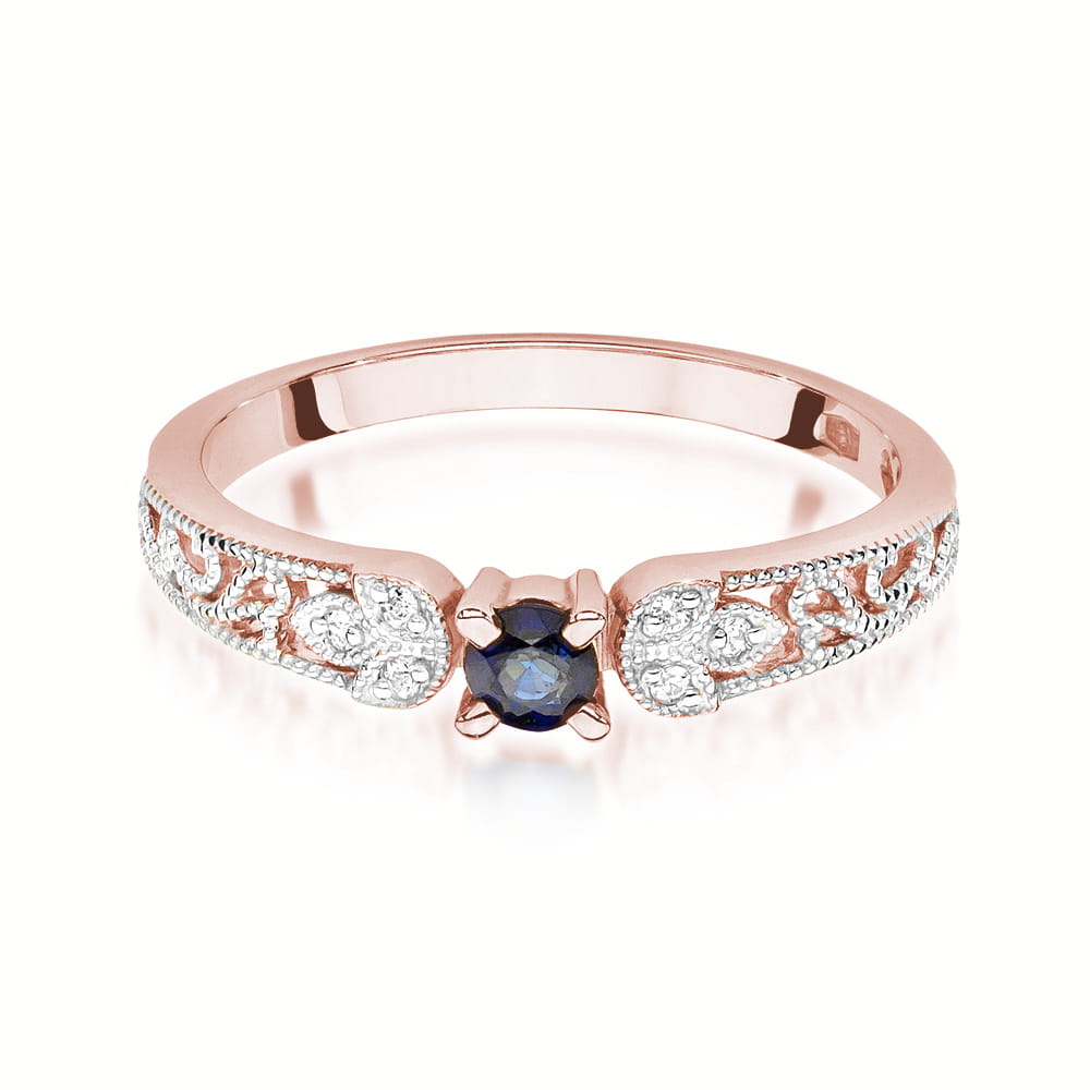 Ein eleganter Verlobungsring aus Roségold 585 mit einem zentralen runden blauen Saphir und Diamanten. Die detaillierte Handwerkskunst und die filigranen Verzierungen sind in dieser Frontansicht zu sehen.