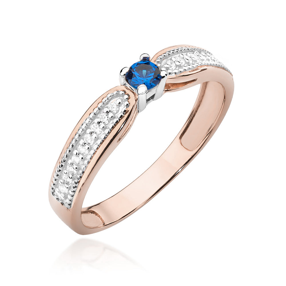 Seitliche Ansicht eines Verlobungsrings aus 14K Roségold mit einem zentralen blauen Saphir und Diamanten. Der Saphir ist in einer modernen Fassung angebracht.