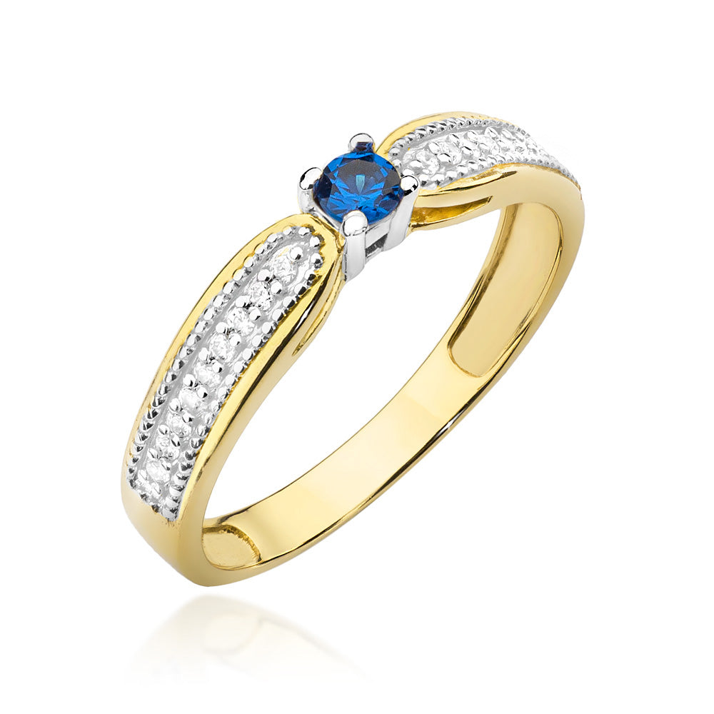 Ein atemberaubender Verlobungsring aus 14K Gold mit einem zentralen blauen Saphir und Diamanten, die kunstvoll in das Band eingearbeitet sind. Der Saphir wird von vier Krappen gehalten.