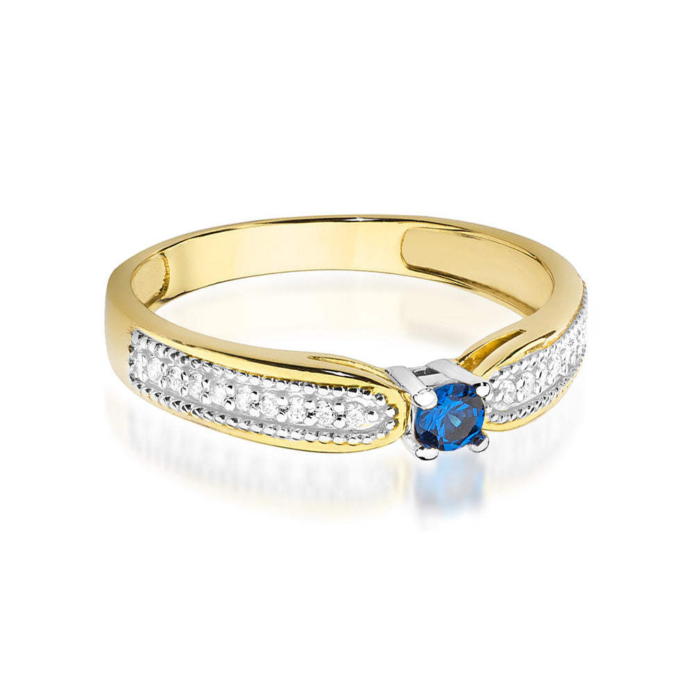 Der 14K Gold Verlobungsring präsentiert sich mit einem zentralen blauen Saphir und funkelnden Diamanten entlang des Bandes. Ein klassisches und zeitloses Design.