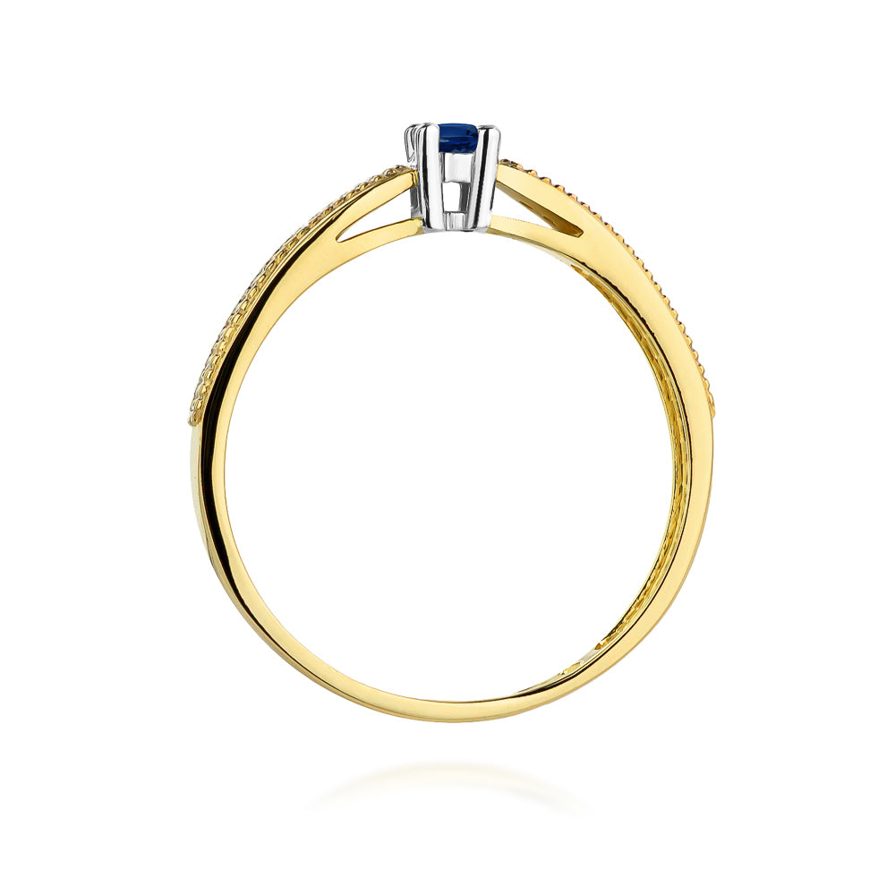 Seitliche Ansicht eines Verlobungsrings aus 14K Gold mit einem zentralen blauen Saphir und Diamanten. Der Saphir ist in einer eleganten Fassung angebracht.