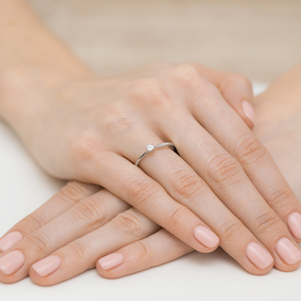 Zarter Verlobungsring aus 14K Weißgold, ideal für den besonderen Moment des Heiratsantrags. Der funkelnde Diamant macht diesen Ring zu einem eleganten und stilvollen Schmuckstück.