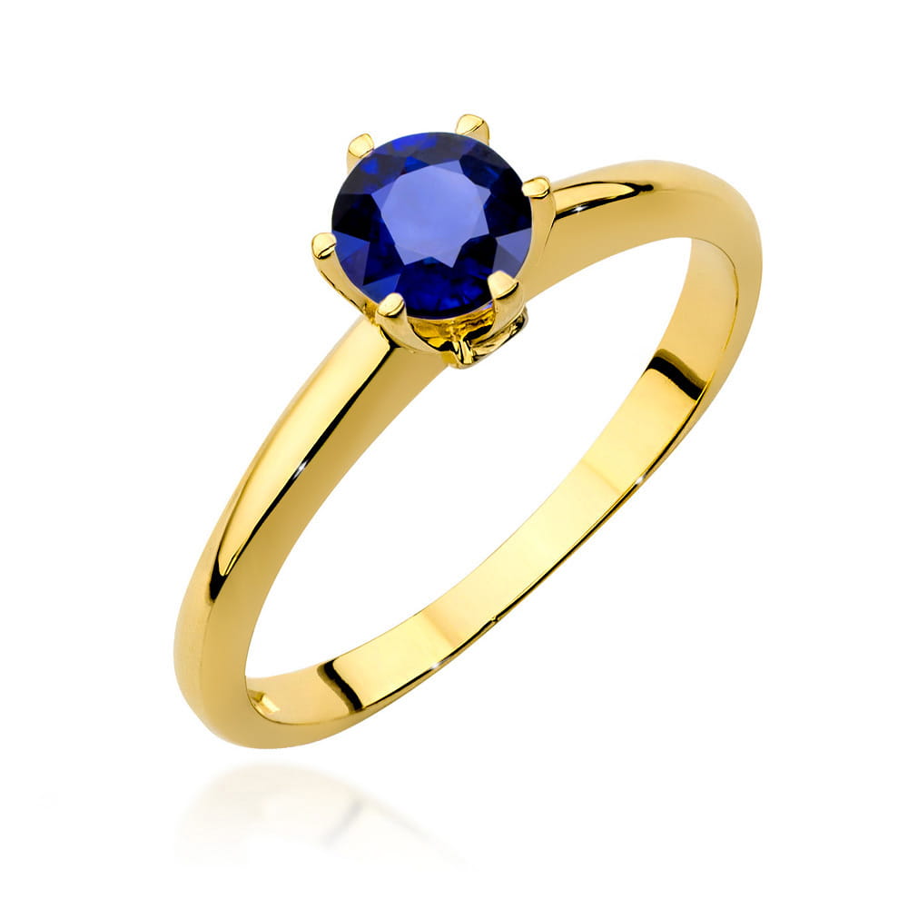 Ein Verlobungsring aus Gold mit einem runden blauen Saphir, auf weißem Hintergrund präsentiert.