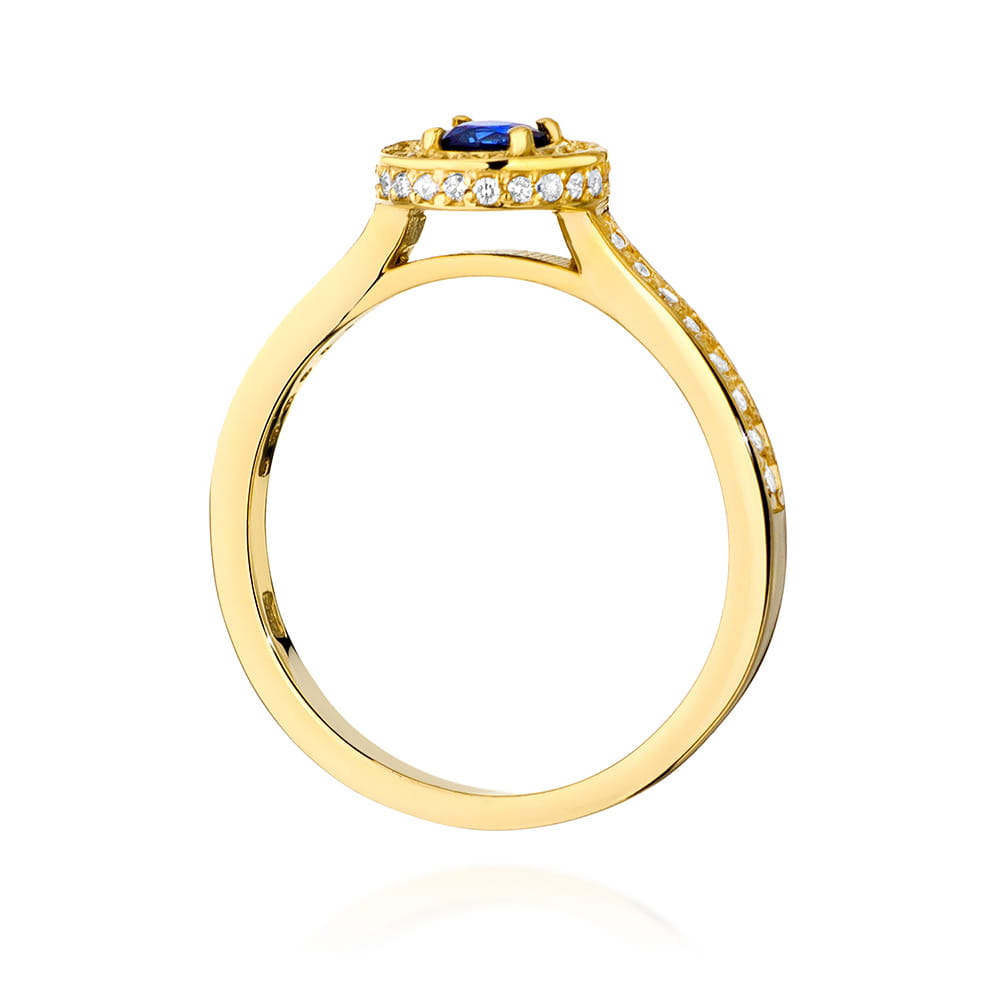 Dieses Bild zeigt die Seitenansicht eines Rings aus 585er Gold. Der Ring hat einen runden Saphir in der Mitte, umgeben von kleinen Diamanten. Die Ringschiene ist ebenfalls mit Diamanten besetzt, was den Ring besonders funkelnd macht.